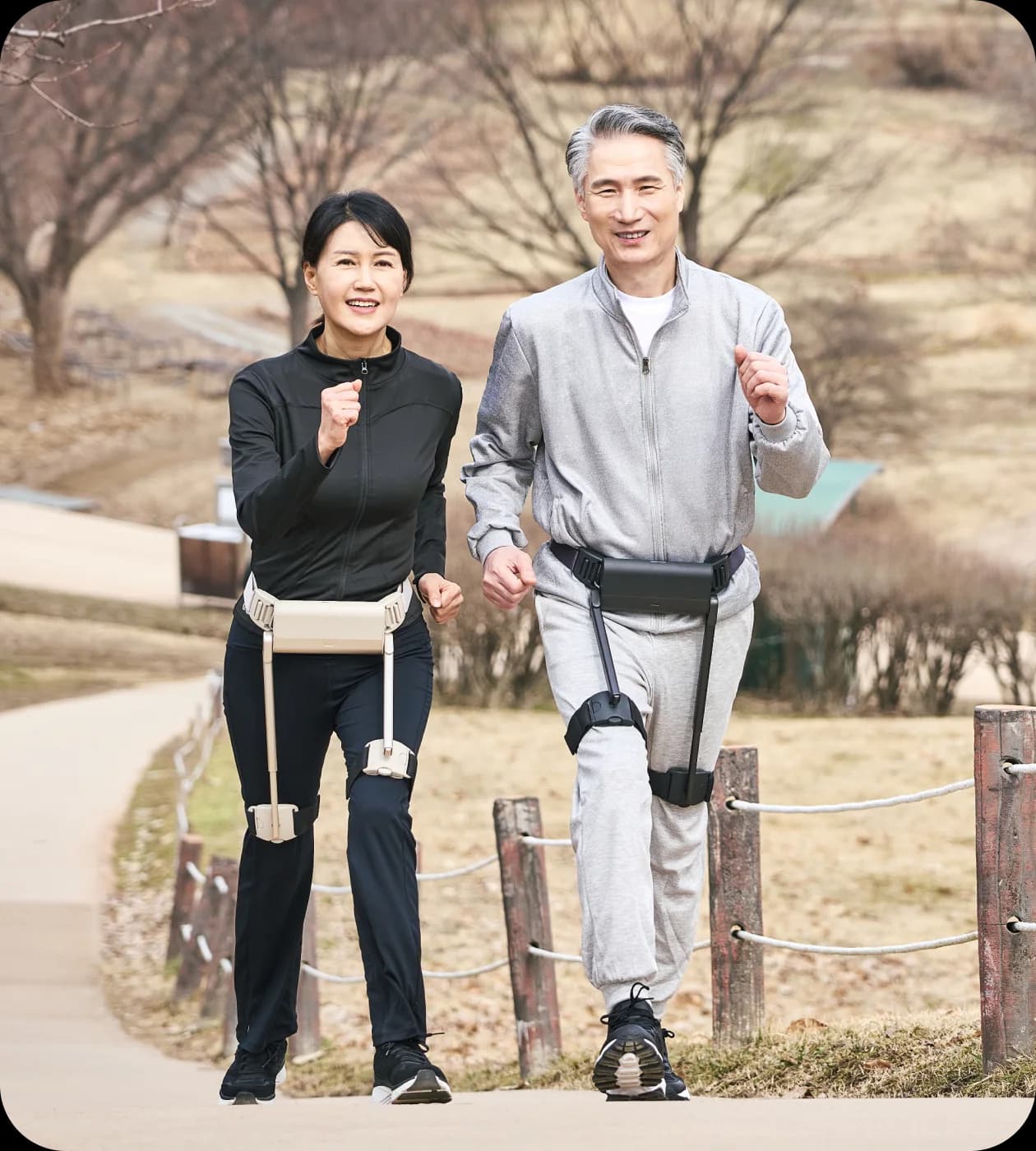 Two adults wearing WIRobotics WIM walk together along an outdoor path.